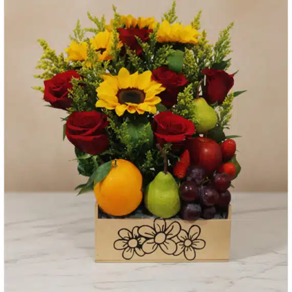 Arreglo floral Adriano con rosas rojas, girasoles vibrantes, naranjas, peras, uvas y fresas en una caja de madera decorada, i