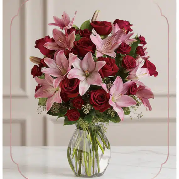 Arreglo floral Nabila con 30 rosas rojas y lirios rosados en un jarrón de cristal, ideal para ecommerce.